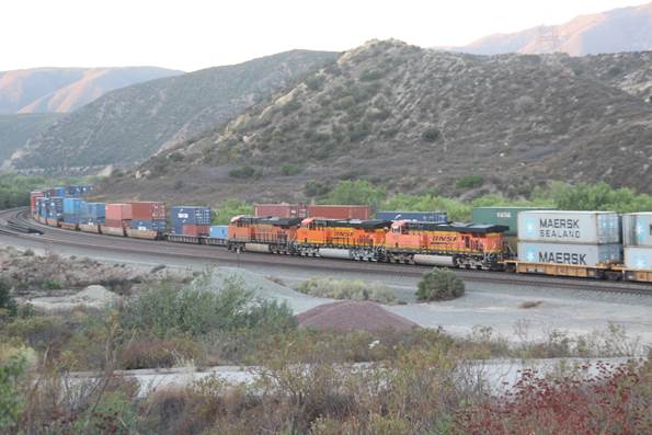This view is from old US 66. BN-SF 7073, a GE ES44C4; BN-SF 8146, a GM SD60M; and BN-SF 7607, a GE ES44DC, pulling a Maersk stack train are seen running on Track #2 at Swarthout Canyon Road.