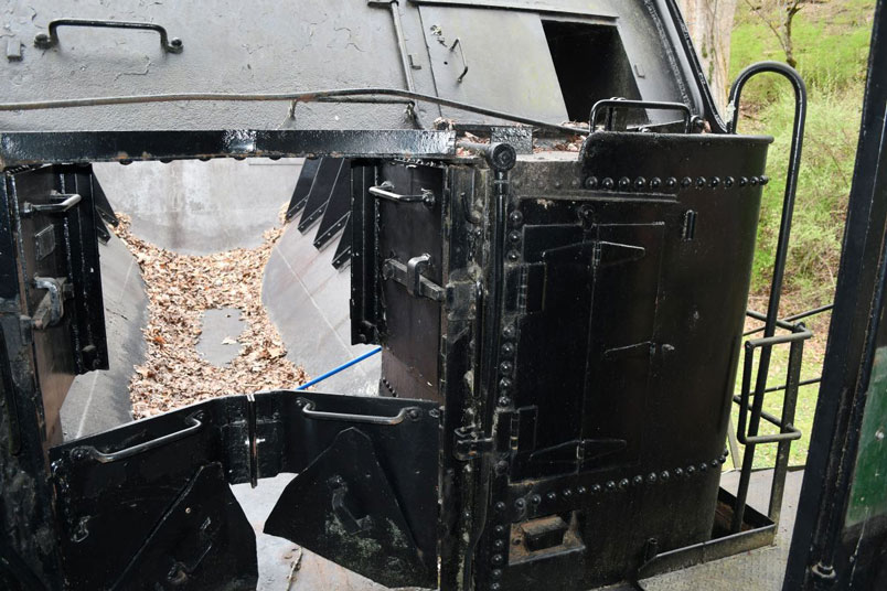 Leaves cover the lid over the stoker screw. Compartments are used for tool storage.