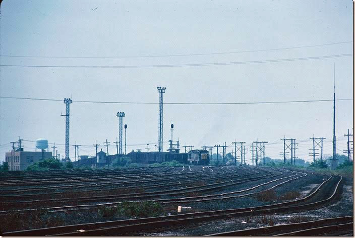 A couple of SD18s shove loads over the coal hump and scales. Note the tall signals which evidently communicate their movements across the hump. 06-27-1976. Russell '76-77.