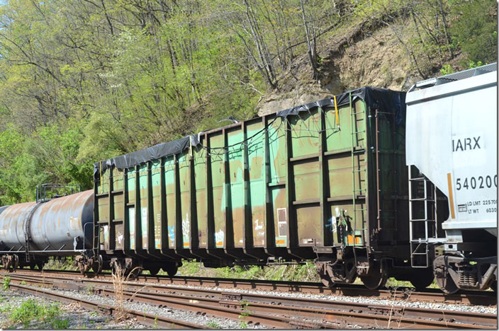 MWCX (Midwest Railcar) gon 100727 on a w/b freight Q652 at Ivel KY on 04-24-2022. Ex-Burlington Northern with 197,400 lbs and built by FMC. I have no idea what is under that tarp.