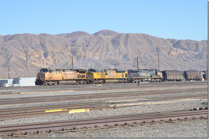 UP 6511-8713-6318 are fueled and pull forward with their coal train. This train is composed of DGHX (Searles Valley Minerals) rapid-discharge hoppers plus a few C&NW fill-ins. This train is likely headed for Mojave and then north on the Lone Pine Br. to Searles. From there it would head over the 30-mile Trona Ry. (owned by Searles Valley Minerals) to the Trona area. Former owner Kerr-McGee Chemical Corp. built the Argus power plant there in 1978. It was the first large industrial power plant in California powered by coal. It serves the company’s three area plants. Yermo CA.