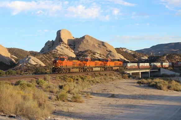 BN-SF 6580, BN-SF 6520, and BN-SF 6554, all GE ES44C4 locomotives, are seen westbound crossing a dry stream bed.