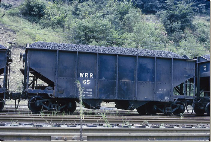 Winifrede Railroad 65 is an ex-N&W H-9. These were built as class HL from 1936-40 with a load limit of 133,500 and a volume of 2,054 cubic feet. N&W rebuilt/repaired/reclassified them at the Princeton WV car shop from 1948-1957. West Carbon WV, 08-20-1973.