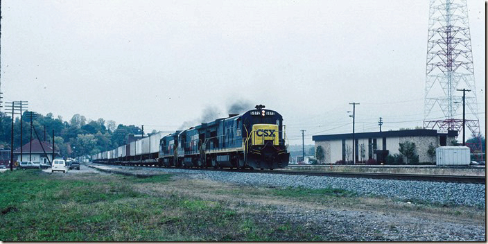 Having changed crews, piggyback train R141 throttle up behind “pig boats” 5872-5916-5824. The division office is on the right. 10-23-1990. CSX Corbin KY.