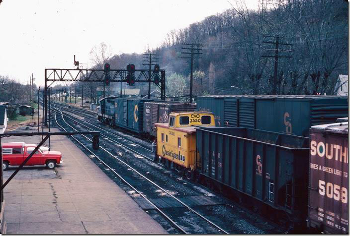 View from RU Cabin as a westbound manifest arrives and 7303 switches the eastbound yard. 11-10-1977. RU Cabin.