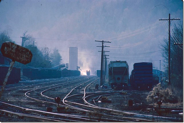 CRR 3000 brakes heavy down the 1.2% grade with coal. Northbound manifests pulled in on the two long sidings on the right. 11-20-1977.