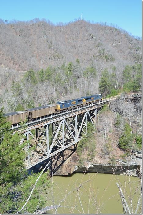 CSX 3028-290 take 107 loads of coal for Duke Energy’s power plant at Brice NC across Pool Point bridge just south of Elkhorn City KY on the Kingsport SD (former Clinchfield). 03-04-2018.
