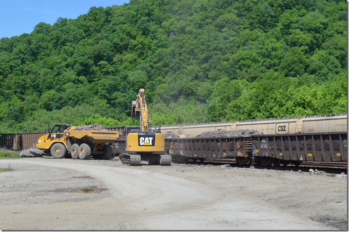 A work train of low side gons is bringing debris from the Robinson Creek Tunnel fire down to Shelby. Here it being unloaded by backhoe and dumped into a vacant lot on CSX property. 