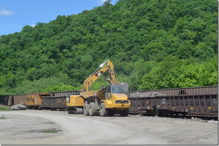 A work train of low side gons is bringing debris from the Robinson Creek Tunnel fire down to Shelby. Here it being unloaded by backhoe and dumped into a vacant lot on CSX property. View 2.