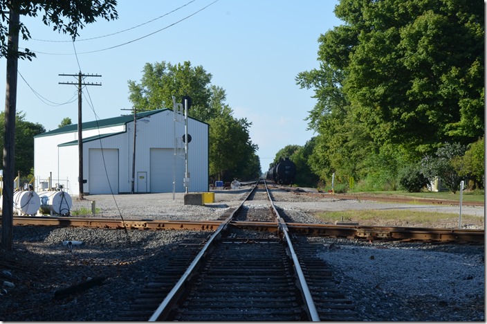 Looking north (west) on the Indiana Eastern (C&O). A bunch of tank cars and an engine (out of site) were parked on the right. The building is IE’s, but it must be for non-rail equipment. Indiana Eastern CSX crossing. Cottage Grove IN.