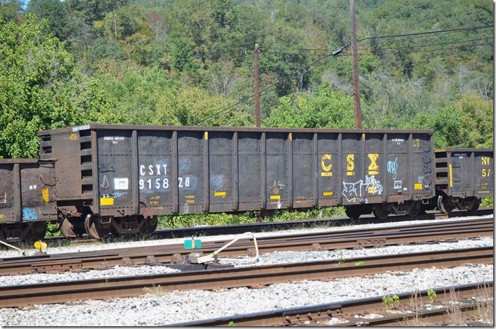 A former CSX “fluff” gon, 915828 is now in the maintenance-of-way fleet hauling scrap ties, etc. On Q697/Q692 at Shelby KY on 09-24-2017.