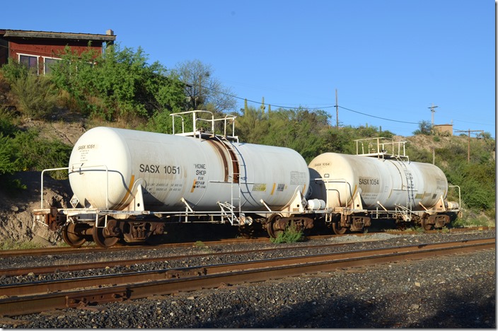 These sulfuric acid tanks were parked at Ray Jct. AZ, on the Copper Basin Railroad awaiting transit to “Home Shop For Repair.” SASX could be Southern Acid & Sulphur, Continental Tank Car Corp., or Olin Mathieson Chemical Corp. Take your pick. They were built in 1989. SASX 1051-1054 tankers.