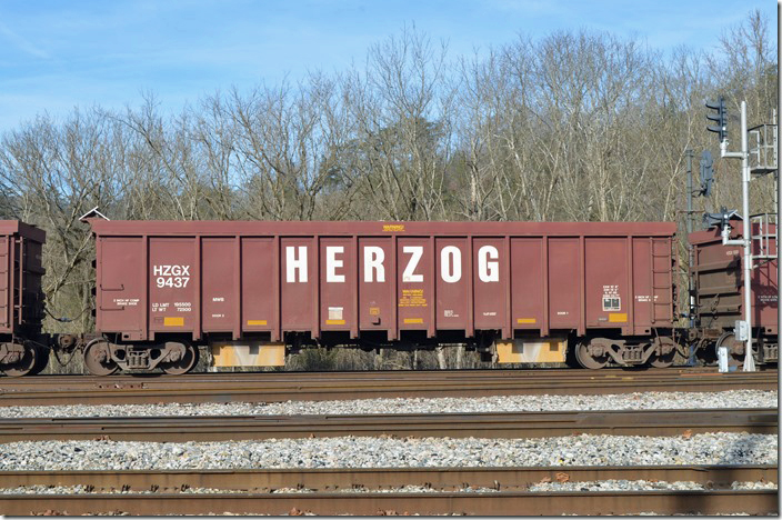 An empty GPS ballast train arrived Shelby eastbound in 12-08-2019 with these leased Herzog Contracting cars equipped for solar power. HZGX MWB 9437. Shelby KY.