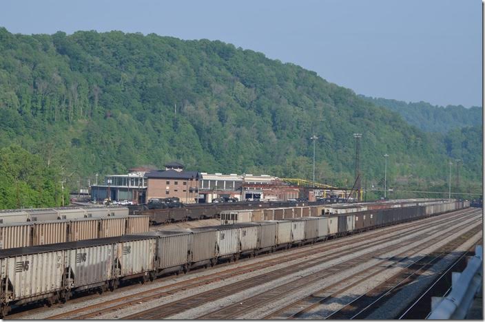 NS 9308-8368-6628 leads w/b grain train 51Q down through the yard on arrival at Williamson WV. The new yard office is named the “John W. Fox” building and is on the left. 05-11-2015.