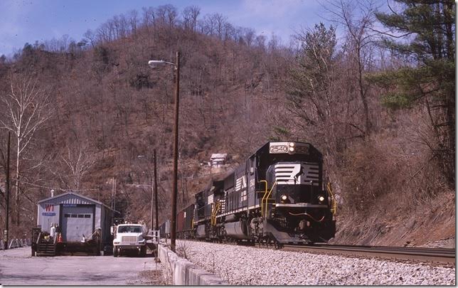 No. 746 barrels through Welch. The building served as the depot after the passenger loop and depot was abandoned downtown. Maintenance of way uses it now. Welch Tunnel is just above the truck.