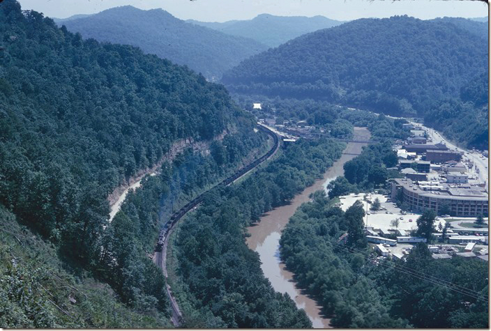 An eastbound C&O coal train leaving the south end of Pikeville from a view point where the Cut-Thru would begin. 08-01-1972. Pikeville KY.