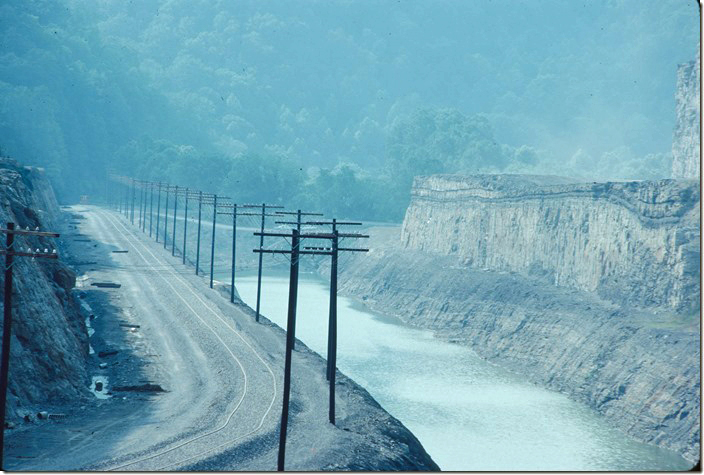 The pole line for the railroad’s telephone lines and signal code lines is up. The track is in place but not yet surfaced. 06-25-1978. C&O in Pikeville KY.