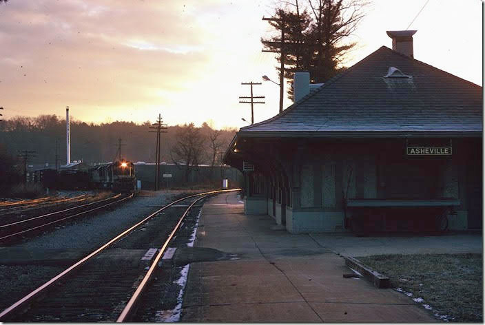 Southern 3020-3003-3122 wait at dawn with a westbound freight from the Salisbury line to enter the yard. 12-23-1973. The line to the right goes down Saluda grade to Spartanburg. I’m waiting to ride the Asheville Special to Greensboro and back. Originally this was the depot for Biltmore. The much larger station for Asheville to the west had been torn down.